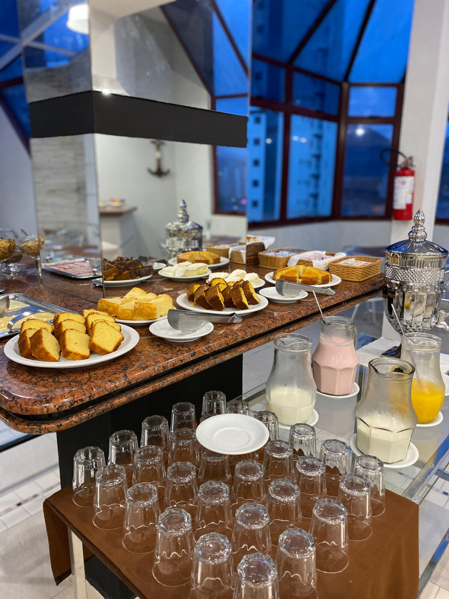 Buffet de café da manhã com bolos caseiros, sucos e bebidas quentes